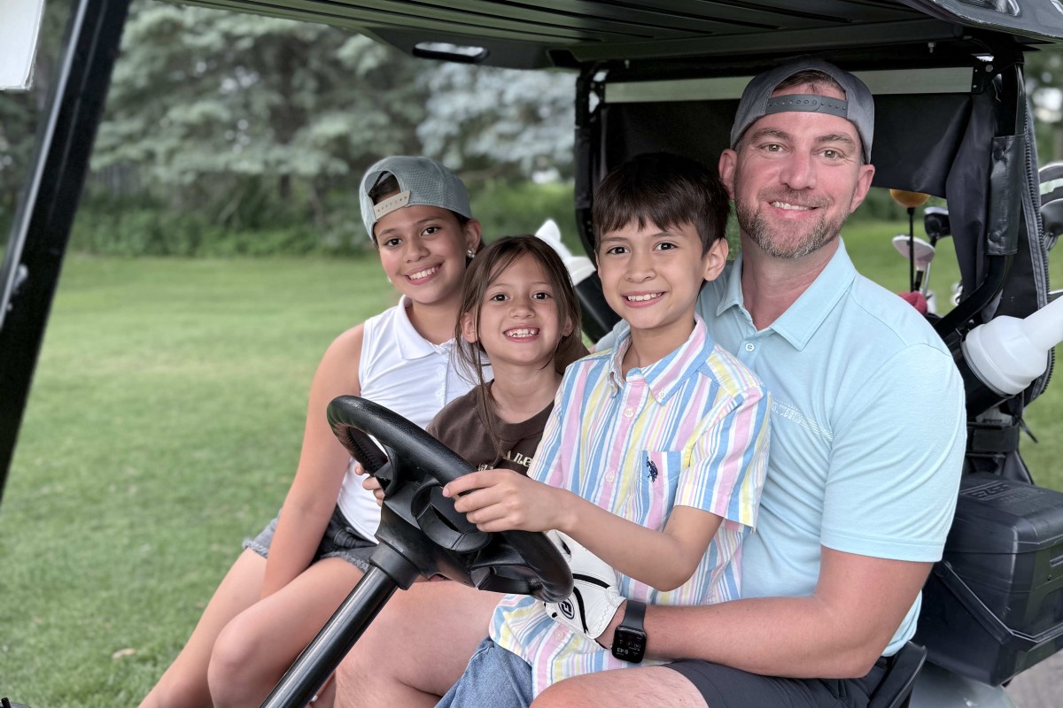 Andrew Malm and his three kids in a golf cart